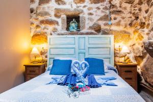 a bedroom with a white bed with blue pillows at La Cuadra in Villar de Corneja