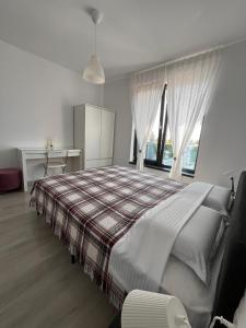 a bedroom with a bed and a desk and a window at Sunset Apartment Otopeni in Otopeni