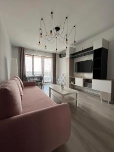 a living room with a couch and a table at Sunset Apartment Otopeni in Otopeni
