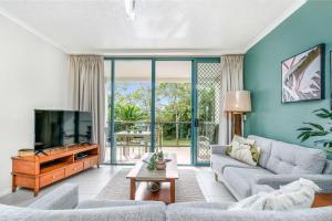 Una sala de estar con un sofá y un televisor. en Shelly Bay Resort, en Hervey Bay