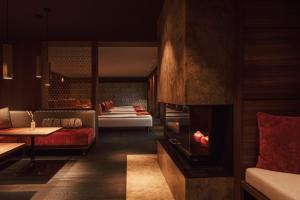 a living room with a fireplace and a couch at Spa & Resort Bachmair Weissach, LUXURY FAMILY RESORT in Rottach-Egern