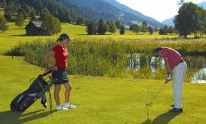 two people playing golf on a golf course at Haus Anni in Bad Kleinkirchheim