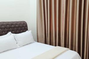 カンガーにあるBumiemas Homestay Kangar Perlisのベッドルーム1室(ベッド1台、茶色のカーテン付)