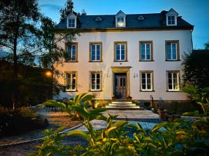 une grande maison blanche avec un toit sombre dans l'établissement Cottage House Weyer - Mare&Filly Room, à Weyer