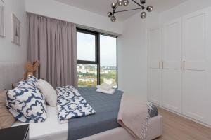 una camera da letto con un letto con una grande finestra di Apartly - Hanza Tower apartament City View, parking, pool, sauna a Stettino Altre 36 foto