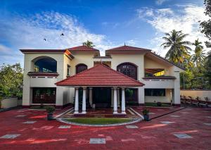 a large house with a red roof at Parvathy Serenity In Varkala in Attingal