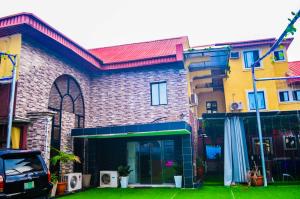 a brick building with a car parked in front of it at Owee Hotel Apartment and Suites in Lagos