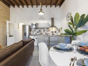 a kitchen and living room with a couch and a table at Terraza de Triana in Seville