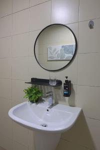 a bathroom sink with a mirror on the wall at Aurora Staycation I-City Shah Alam in Kampong Padang Jawa