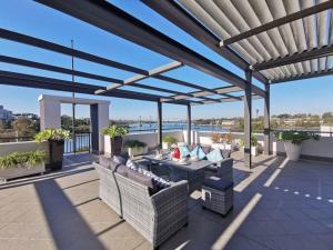 a patio with furniture and a view of the water at Breathtaking Waterfront Penthouse with BigTerrace near to Olympic Park in Sydney