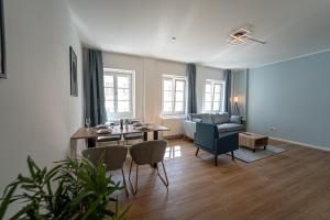 a living room with a table and chairs and a couch at LUXOMES - Vilshofen Altstadt Apartments in Vilshofen an der Donau