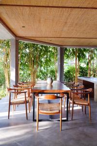 a wooden table and chairs on a patio at Planta Boutique Resort in Canggu