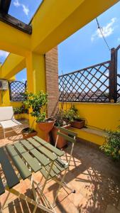 une maison jaune avec une chaise verte sur un patio dans l'établissement Un sacco di vento, à Marino