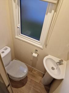 a bathroom with a toilet and a sink and a window at 163 Holiday Resort Unity Brean sands Pet friendly in Berrow +23 photos