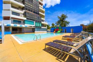 a swimming pool with chairs and a playground in a building at Beachfront 2 bed Condo with Seaview! - BW2 in Hua Hin