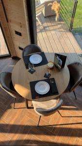 a wooden table with chairs and plates on it at Complex A Toplita in Topliţa