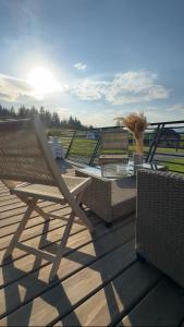 a wooden deck with a chair and a table at Complex A Toplita in Topliţa +58 photos