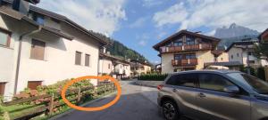 a car parked next to a building with an orange circle at La casa dello scoiattolo primierotto in Tonadico