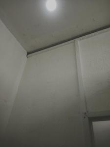 a room with a white wall and a ceiling at Rumah Putih Edi in Sengkol