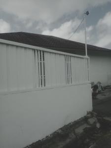 a white fence in front of a house at Rumah Putih Edi in Sengkol