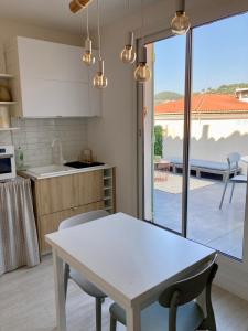 una cucina con tavolo e vista su un patio di Havre cosy et familial, garage, centre ville, dans la cité des Potiers a Vallauris Altre 6 foto