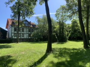 a house in the middle of a field with trees at Poppenhäuser Mühle in Hofgeismar