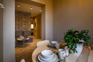 a living room with a table with plates and a plant at Liepaja Apartments Parkside in Liepāja