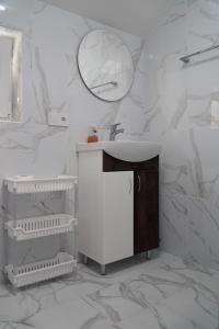 a white bathroom with a sink and a mirror at Yellow House in Pilipets