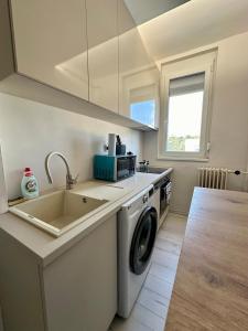 塞格德Mate Gold Apartment II的配有洗衣机和水槽的厨房