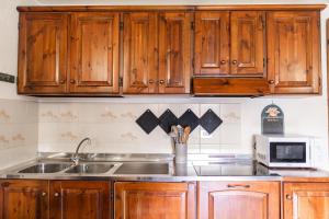 a kitchen with wooden cabinets and a sink at [Aosta - La Thuile] - Condominio Rolland in La Thuile +11 photos