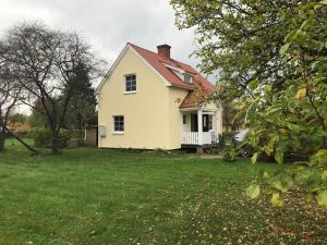 a white house with a red roof on a yard at Sommar och vinter i Rottneros in Sunne