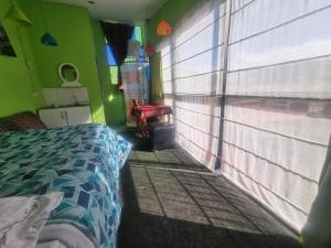 Un dormitorio con una cama y una pared verde. en IG Suites & Apartment, en Cusco
