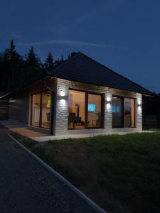 a small house with lights on the side of it at Vikendica Krlic in Mitrovac