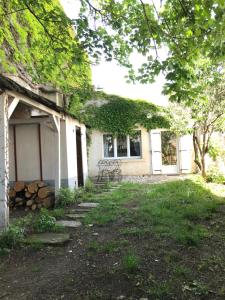 a house with a yard with a building at La vigne vierge in Saint-Pierre-dʼOléron