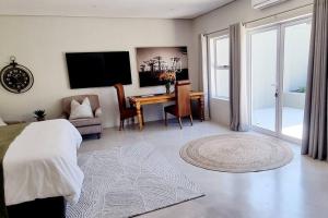 Un dormitorio con una cama y un escritorio con televisión. en C'est la Vie 1, en Franschhoek 31 fotos más