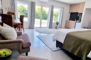 a bedroom with a bed and a living room at C'est la Vie 1 Self-catering apartment with private hot tub in Franschhoek