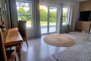 sala de estar con 2 ventanas grandes y alfombra en C'est la Vie 1, en Franschhoek