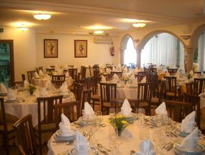 a banquet hall with tables and chairs with white tablecloths at Falcao de Mendonca in Figueira de Castelo Rodrigo