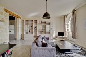 un soggiorno con un divano e un tavolo di Le Richelieu - Magnifique duplex avec une vue Incroyable a Bordeaux