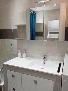 une salle de bain avec un lavabo blanc et un miroir dans l'établissement Grand appartement proche port et plages, 6 à 8 pers, 3 chambres, climatisé, au Cap d'Agde 23 autres photos
