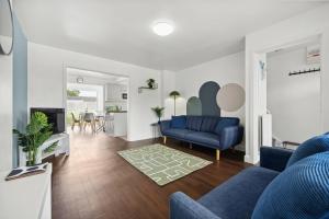 a living room with a blue chair and a blue couch at Stylish Home From Home 3 bed house, sleeps 6, private parking, WiFi Leamington Spa in Leamington Spa