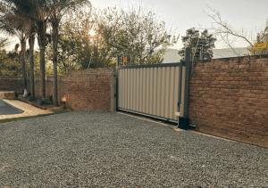 una valla de ladrillo con una puerta y una pared de ladrillo en Molenhof, en Somerset East