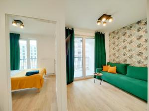a bedroom with a green couch and a bed at Wygodne Mieszkania Nova Mikołowska Apartamenty in Katowice