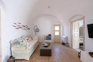 Una sala de estar blanca con un sofá y una mesa. en Art Canava Luxury Villas, en Fira