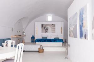 una habitación blanca con una cama y una mesa en Art Canava Luxury Villas, en Fira
