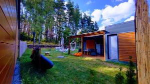 una casa con un patio con una tienda y una mesa en Kwiat Jabłonki, en Wikno
