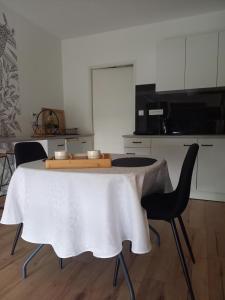 a kitchen with a table with chairs and a microwave at L'appart des mésanges in LʼHerbergement