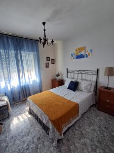 a bedroom with a bed and a chandelier at El Corralillo de Victorina in San Martín de Valdeiglesias