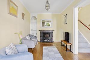 een woonkamer met een bank en een open haard bij Cherub Cottage located in the centre of Historic Dartmouth in Dartmouth