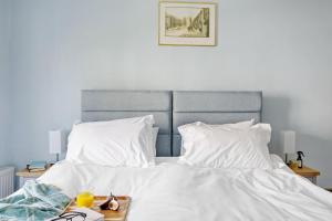 een slaapkamer met een bed met witte lakens en kussens bij Cherub Cottage located in the centre of Historic Dartmouth in Dartmouth